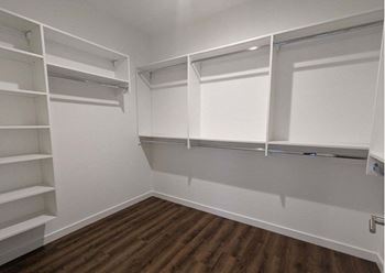 a walk in closet with white shelves at The Point at Gateways, New Jersey, 07869